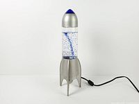 Full front view of rocket motion lamp showing base, cylinder with glitter, cap and power cord