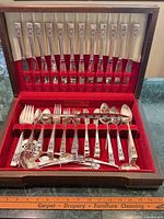 Full view of open storage chest showing all flatware pieces arranged