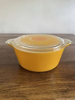 Yellow Pyrex casserole with sunflower lid front angle