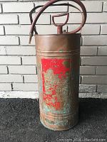 Full front view of copper pump tank showing embossed Walter Kidde logo plate with red paint and attached hose.
