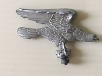Front angled view of the eagle-shaped metal hood/fender ornament showing detail and patina.