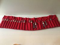 Full view of all twenty vintage miner's sample vials in bright red felt packaging on a white surface.