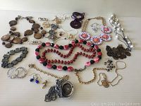 Full lot of costume jewellery showing necklaces, bracelets, earrings, and brooches.