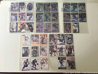 Top view of 43 Wayne Gretzky hockey cards arranged in plastic sleeves, showing varied designs and conditions.