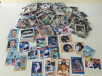 Top view of a pile of vintage baseball cards showing various players including pitcher and batter images, colorful border designs, and classic pose photos.