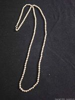 Full view of sterling silver ball chain necklace laid flat