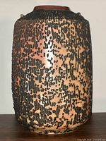 Full view of cylindrical vase showing textured surface and coloration