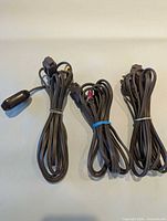 Three coiled brown extension cords side by side