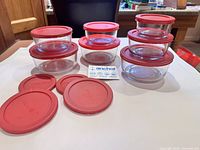 Full set of glass bowls with lids displayed on table
