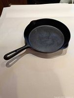 Top view of cast iron skillet showing interior cooking surface, handle, and pour spout