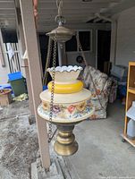 Full view of hanging painted glass and brass pendant lamp with chains