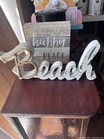 Beach word sign and happy place block sign on tabletop