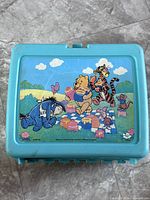 Front of teal lunch box showing Pooh picnic graphic