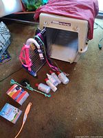 Overall lot showing carrier, leashes, CHI bottles, rope toy, Halt! spray