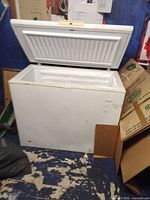Front view of white chest freezer with lid open