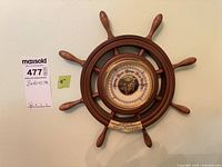 Full view of wood ship wheel barometer hanging on wall
