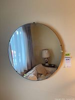 Front view of round mirror reflecting room furnishings