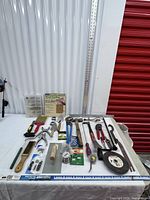 Overall view of hand tools and hardware laid out on table