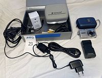 All items laid out including camera, charger, case, Samsonite adapter kit, plug adapter, cables