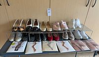All 11 shoe pairs, hosiery packages and wire rack displayed on table