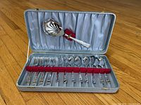 Open presentation case displaying all 13 flatware pieces and interior lining