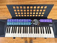 Top view of Yamaha PSR-77 keyboard on stand with music holder