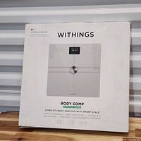 Front of retail box showing Withings Body Comp scale image and feature list