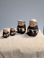Four Friar Tuck pieces displayed on cloth