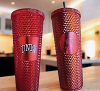 Two red studded Starbucks cold cups showing UNLV logo and siren logo
