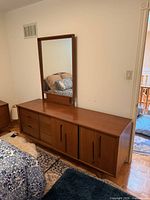 Front view dresser with mirror attached, shows wood finish and storage layout