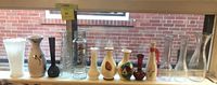 Full lineup of 12 assorted vases on windowsill