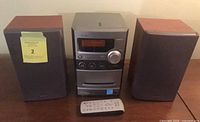 Front view showing main unit, both speakers and remote