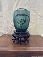 Frontal view of vase on stand showing floral motif