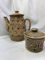 Teapot and sugar bowl side by side showing pattern and color