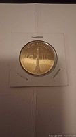 Obverse of coin showing Alan Shepard inscription and rocket