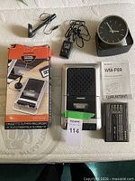 Group shot of all items: Sylvania recorder, Sony Walkman, microphone, adapter, clock, box, manual