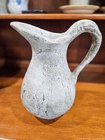 Front view of concrete pitcher vase showing distressed gray/white finish
