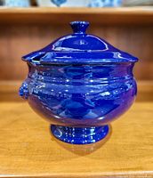 Front view of cobalt blue soup tureen with lid on footed base