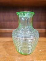 Front angled view of uranium glass decanter showing ribbed body and green tint