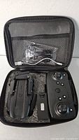 Open carry case showing drone, controller, battery, cable pack