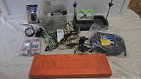 Overview of lot showing wiring harnesses, packaged connectors, LED light, WarnPack triangle case, coiled cable, plastic bin of hardware