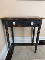 Front view showing table, drawer, knobs, legs