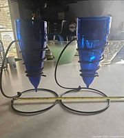 Front view of both cobalt blue glass candle holders in metal spiral stands