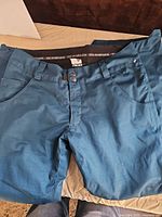 Full view of teal snowboarding pants front side