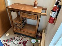 Full view of wooden kitchen cart showing top, drawers, shelves and casters