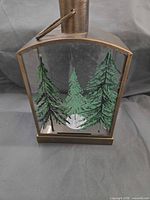 Front view showing pine tree graphic on glass panel and metal frame