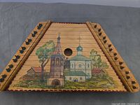 Top view showing painted scene, soundhole and tuning pins