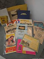 Overview of entire lot showing recipe booklets, BOAC log book, postcard folders and brochures
