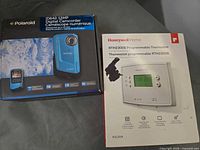 Both product boxes: Polaroid camcorder and Honeywell thermostat