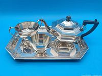 Full view of four-piece silver-plated tea set on tray